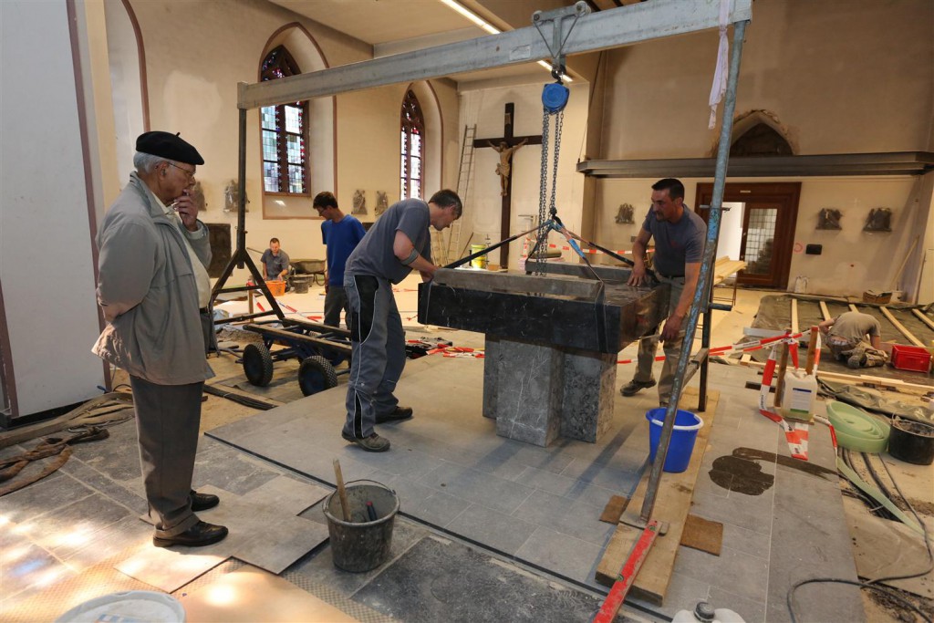 Pfarrer Francis Chirayath (links) beobachtet, wie der Altar in der Konzener Pfarrkirche wieder aufgestellt wird: Die Umbauarbeiten gehen gut voran, so dass das Ergebnis bald besichtigt werden kann. Foto: A. Gabbert